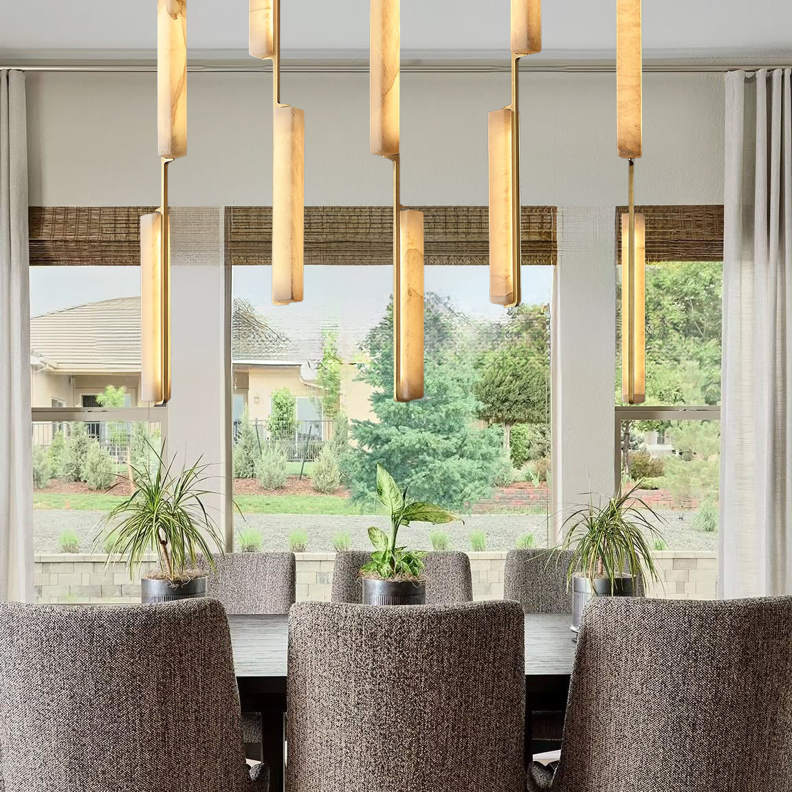 Dining room with a large window, modern pendant lights, and gray chairs.